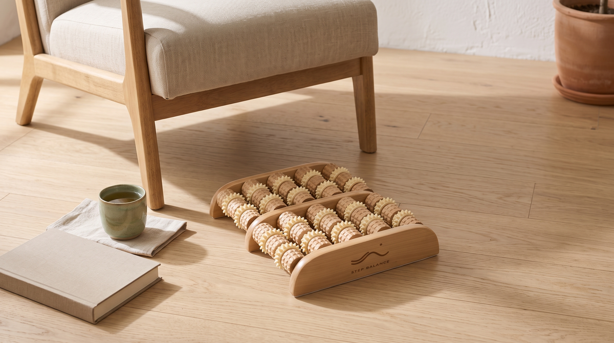 Step Balance ReflexRoll wooden foot roller on an oak floor beside a linen armchair, with a cup of tea and a book